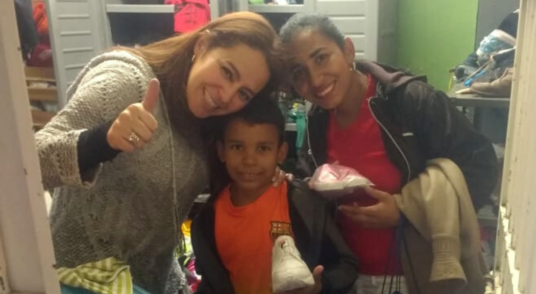 Funcionaria Claudia Milena Upegui posa con una mujer y un niño beneficiados con su emprendimiento.