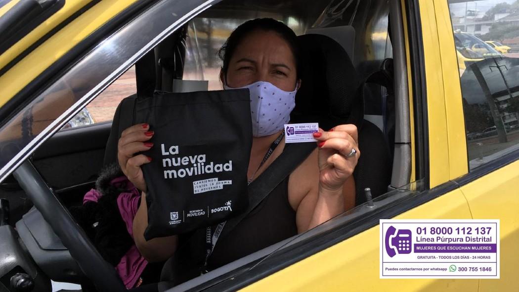 Mujer taxista recibiendo el sticker de la Línea Púrpura.