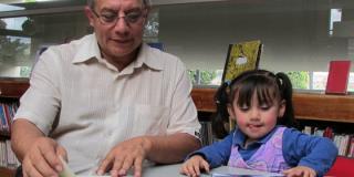 Abuelo leyendo a su nieta - Foto: bogota.gov.co - Carolina Duarte