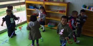 Plano general de un grupo de niños jugando en un jardín infantil.