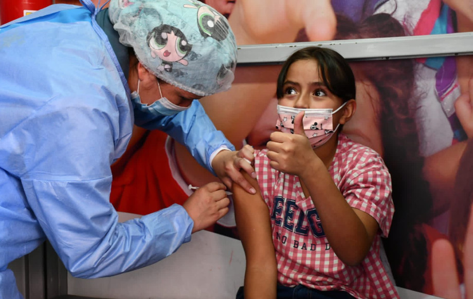 Enfermera vacunando a una persona menor de edad