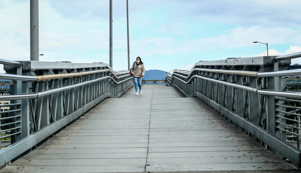 Fotografía de mujer en un puente peatonal.