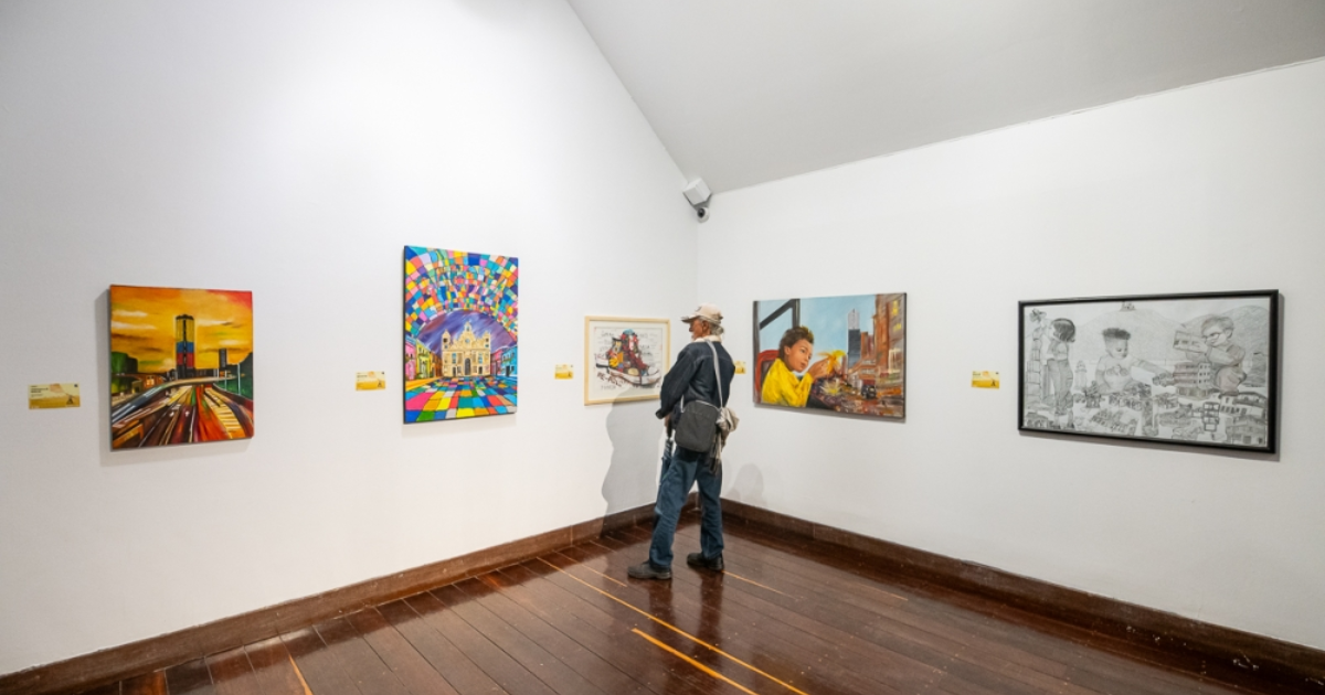 Imagen con hombre recorriendo galeria con obras de arte en pared blanca