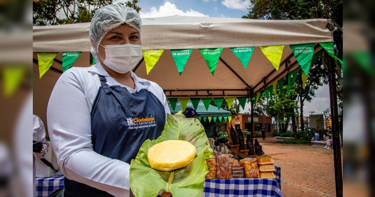 Foto de una de las mujeres que integran los Mercados Campesinos de Bogotá y productos lácteos.