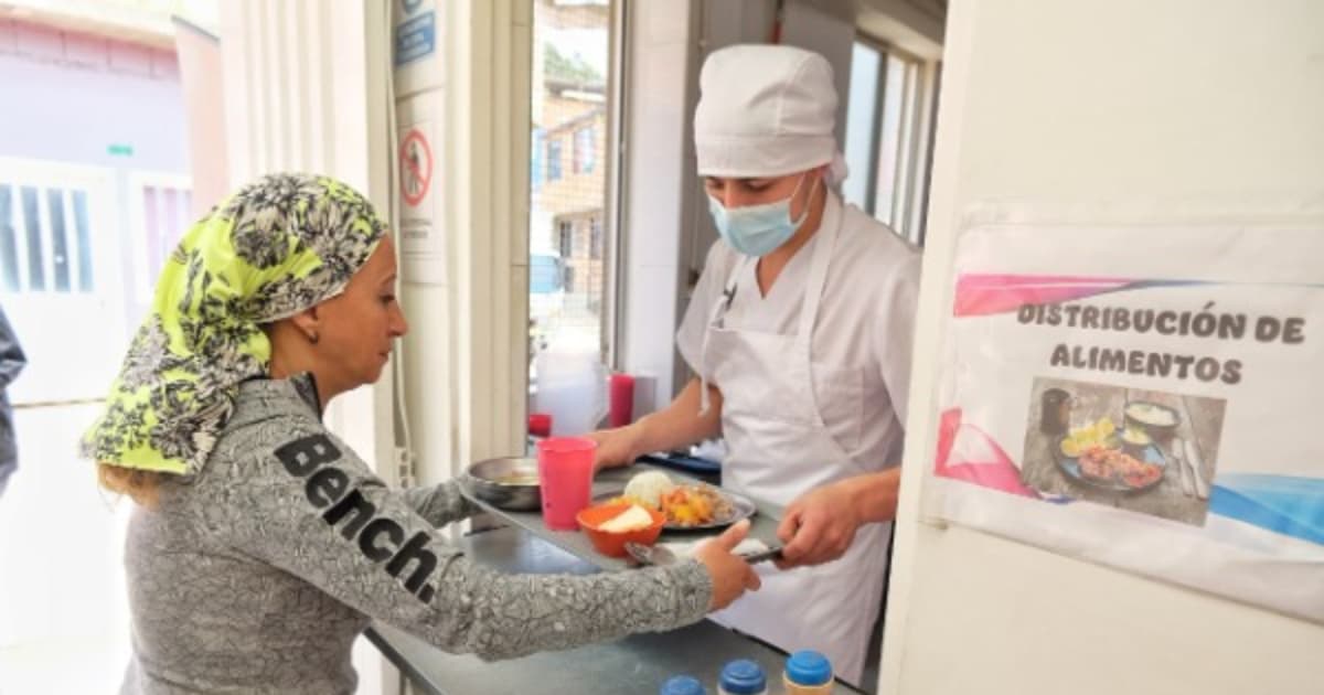 Una persona recibiendo alimentos en un comedor comunitario 