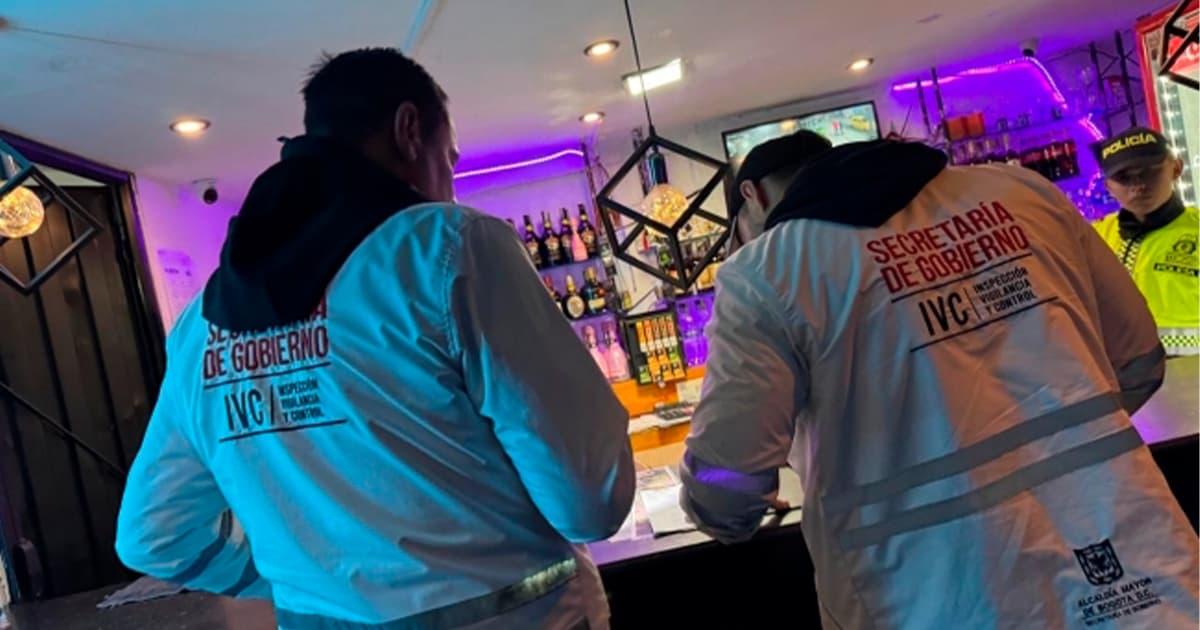 En la foto dos personas haciendo operativos de Inspección, Vigilancia y Control en un bar
