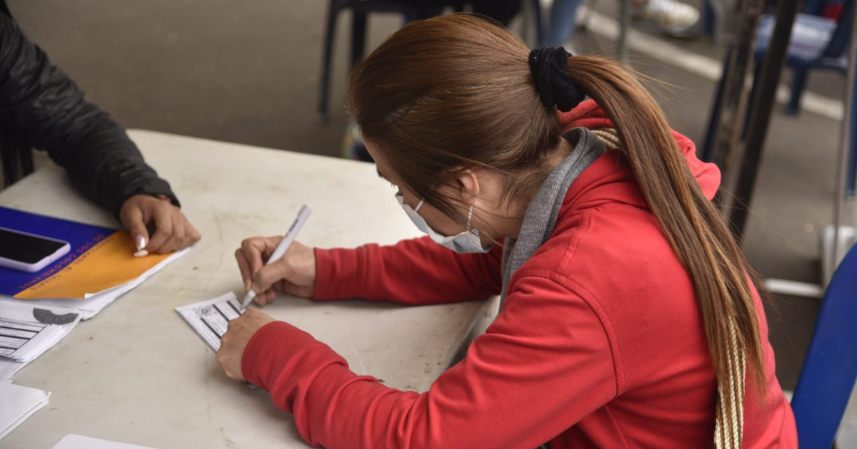 Imagen de una mujer firmando una hoja