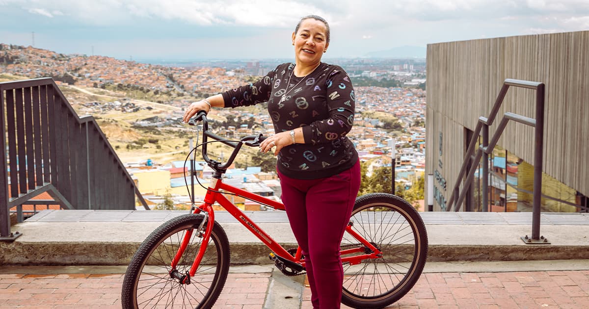 En la foto una beneficiaria en una bicicleta en la localidad de Ciudad Bolívar 