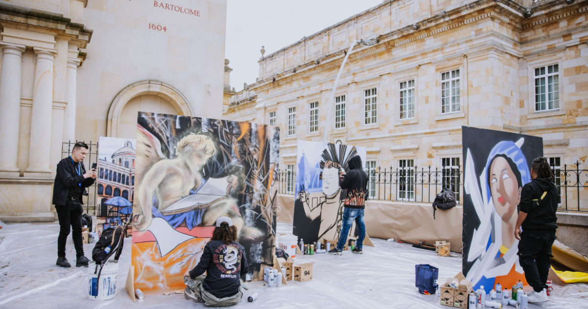 Imagen de varios artistas del gafiti pintando sus obras y de fondo la iglesia de San Francisco