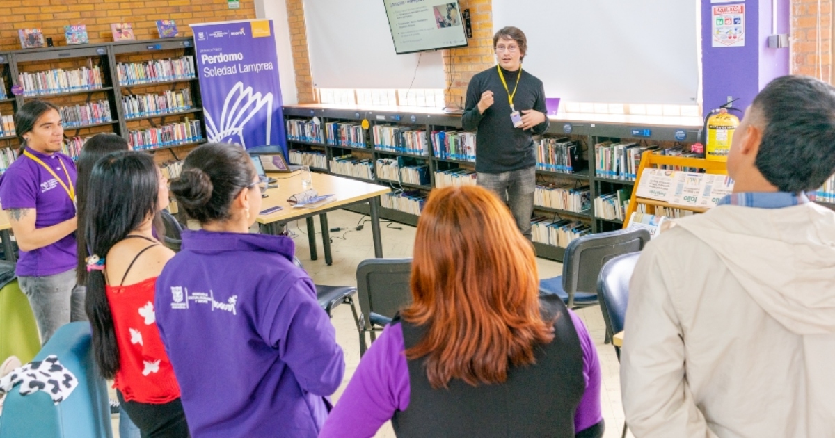Foto que muestra personas hablando en una biblioteca