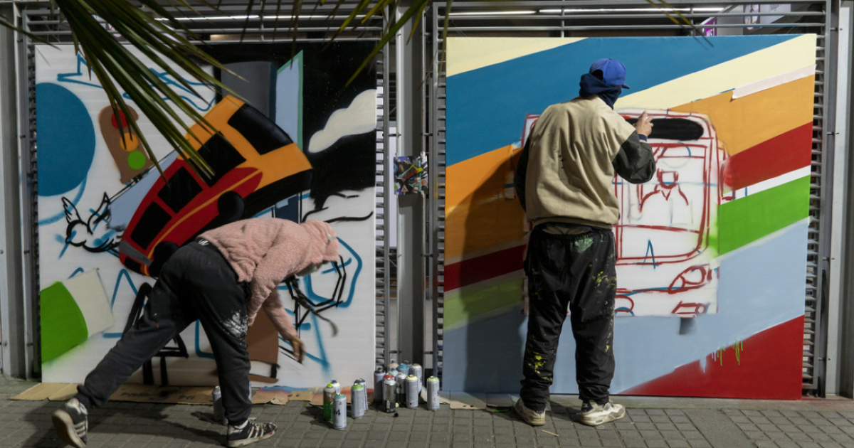 Imagen de dos artistas interviniendo una estación de TransMilenio