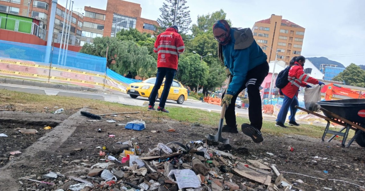 Foto que muestra una persona recogiendo residuos del piso con una pala 