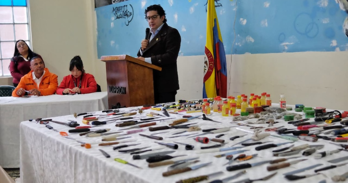 Imagen del secretario de integración social al lado de las armas que entregaron los y las jóvenes