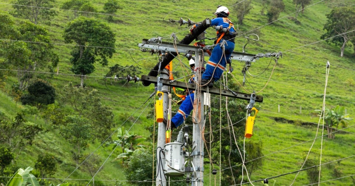 Foto que muestra trabajadores de Enel Colombia realizando sus labores en un poste de luz.