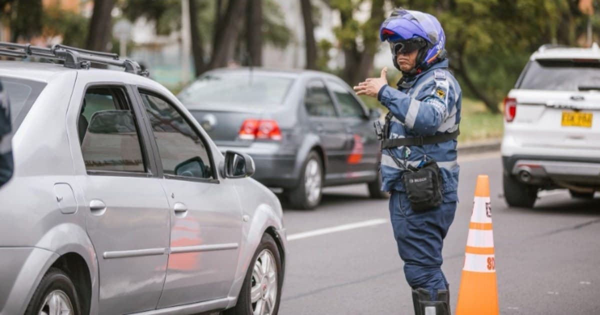 Foto que muestra vehículos andando por las calles y un policía de transito