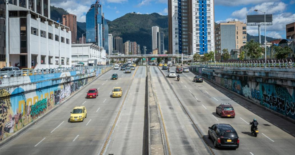 Imagen panorámica de la calle 26 de Bogotá donde se aprecia tráfico de vehículos aprticulare y taxis