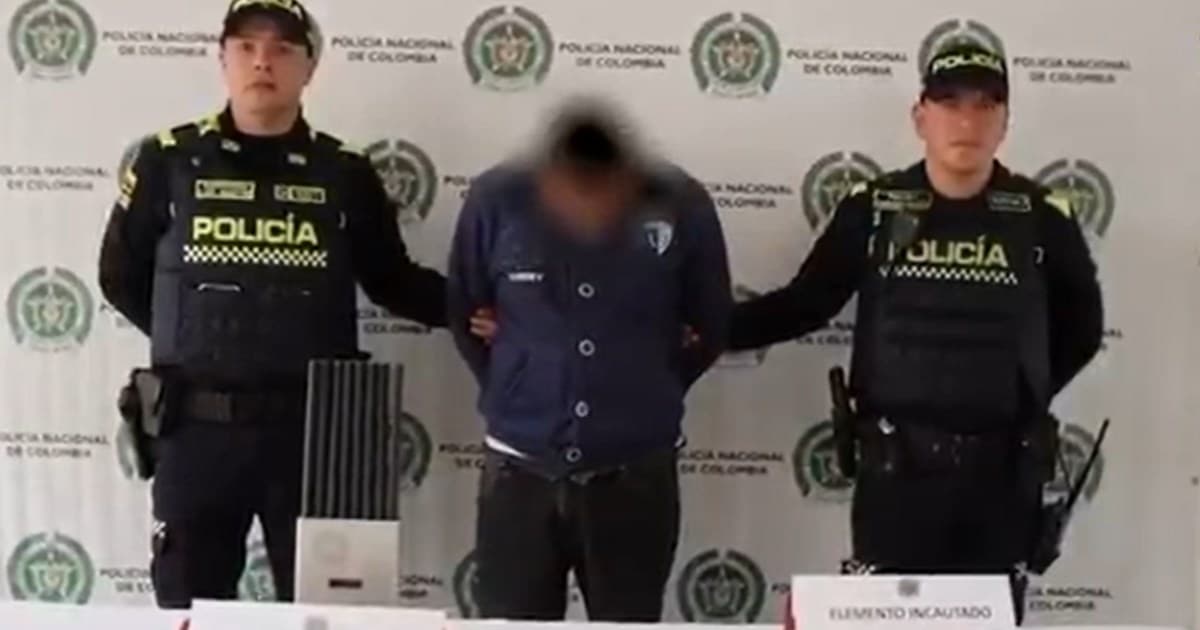 Foto de un hombre capturado en medio de dos policías 