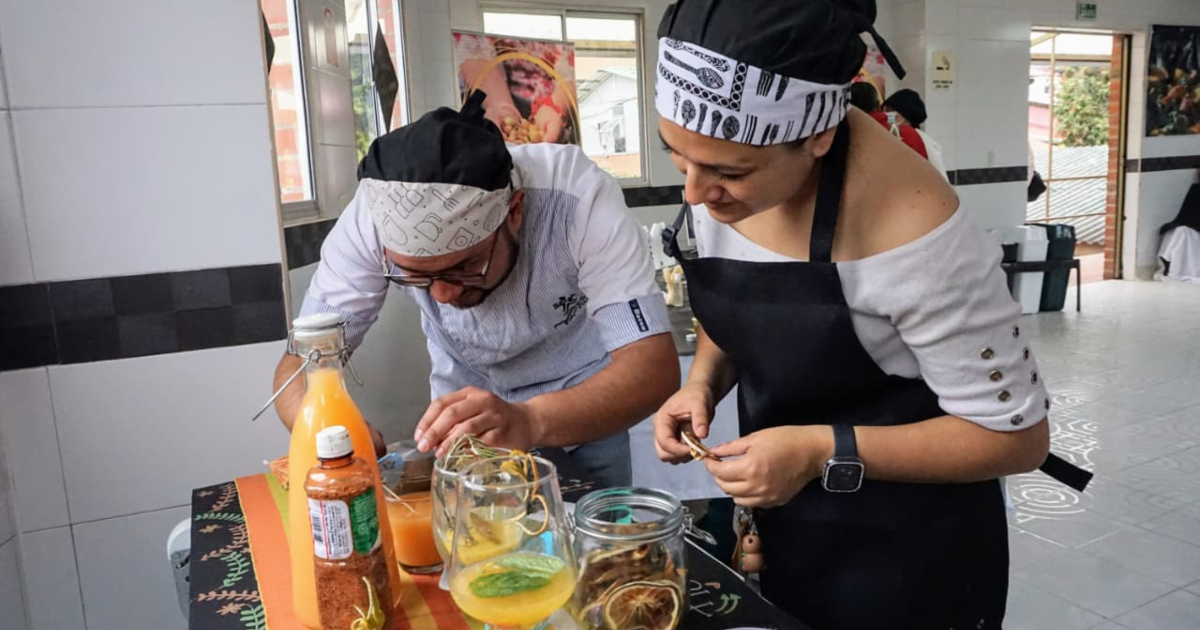 Imagen de un y una chef cocinando.