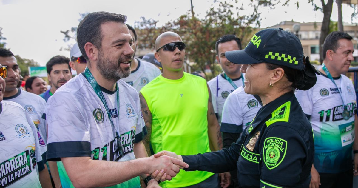 Imagen del alcalde Galán dándole la mano a una policía después de la carrera