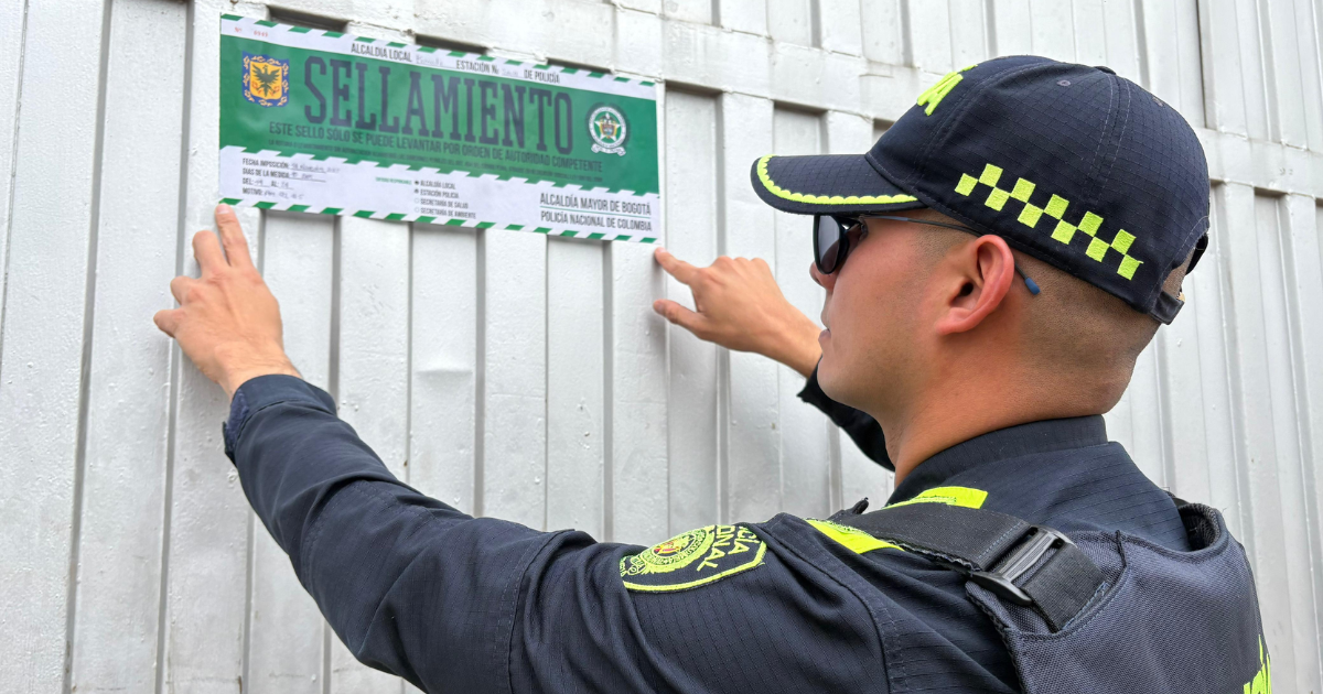 Foto de un policía sellando un establecimiento en Bogotá