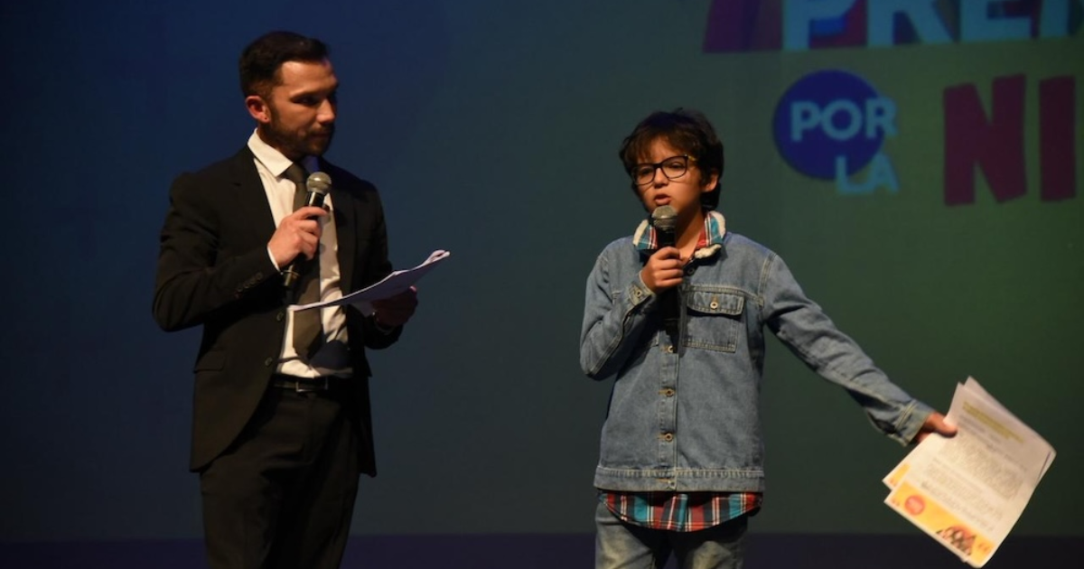 Imagen de un niño hablando ante el público en una tarima