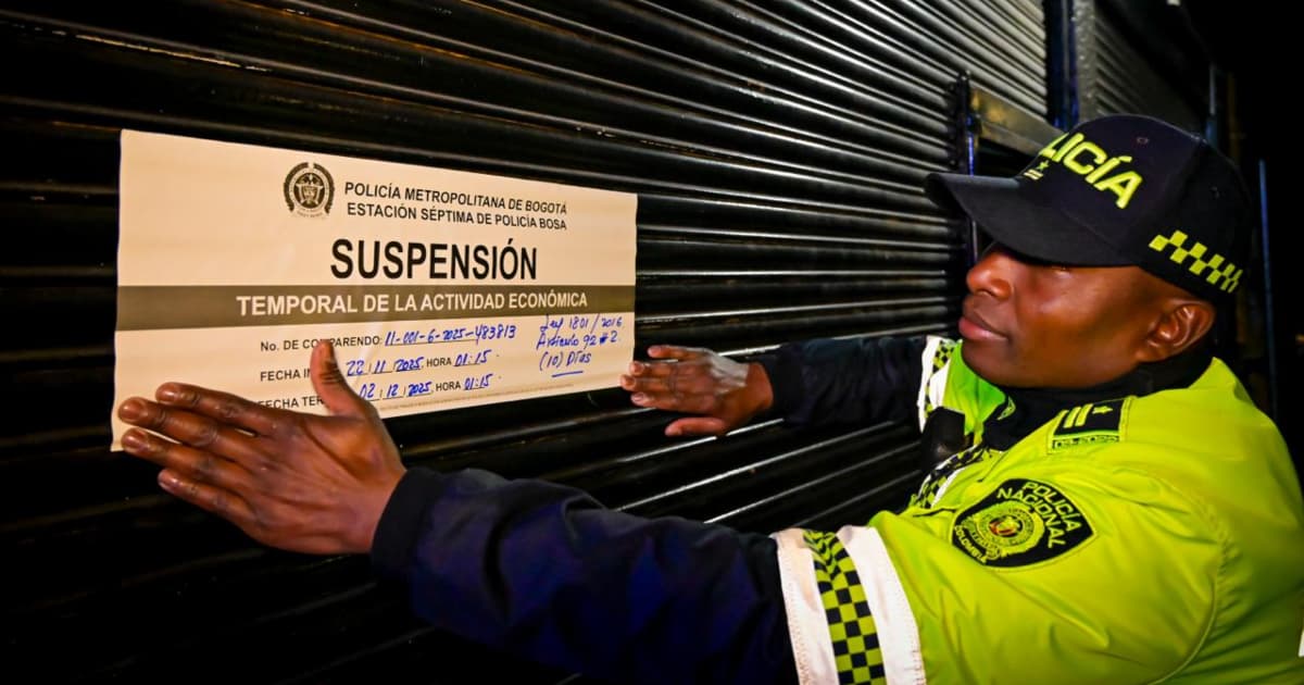 Policía pegando cartel de suspensión