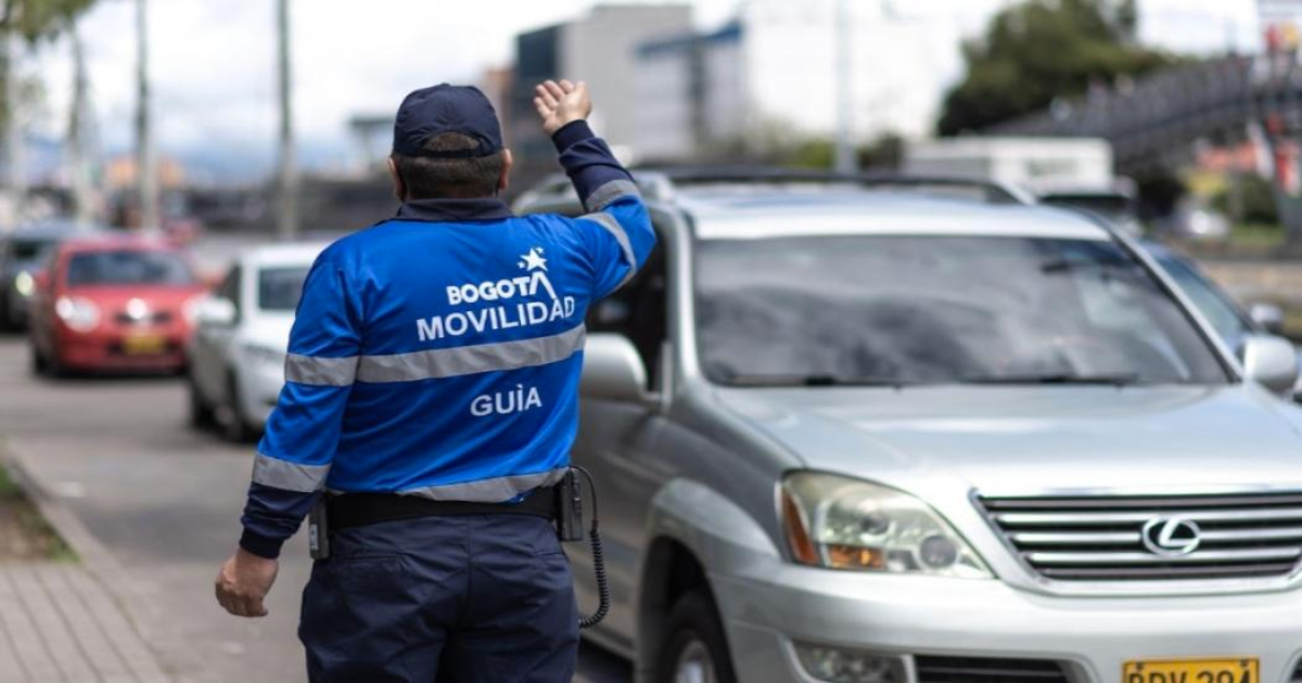 Imagen de un agente de tránsito que conversa con el conductor de un vehículo particular.