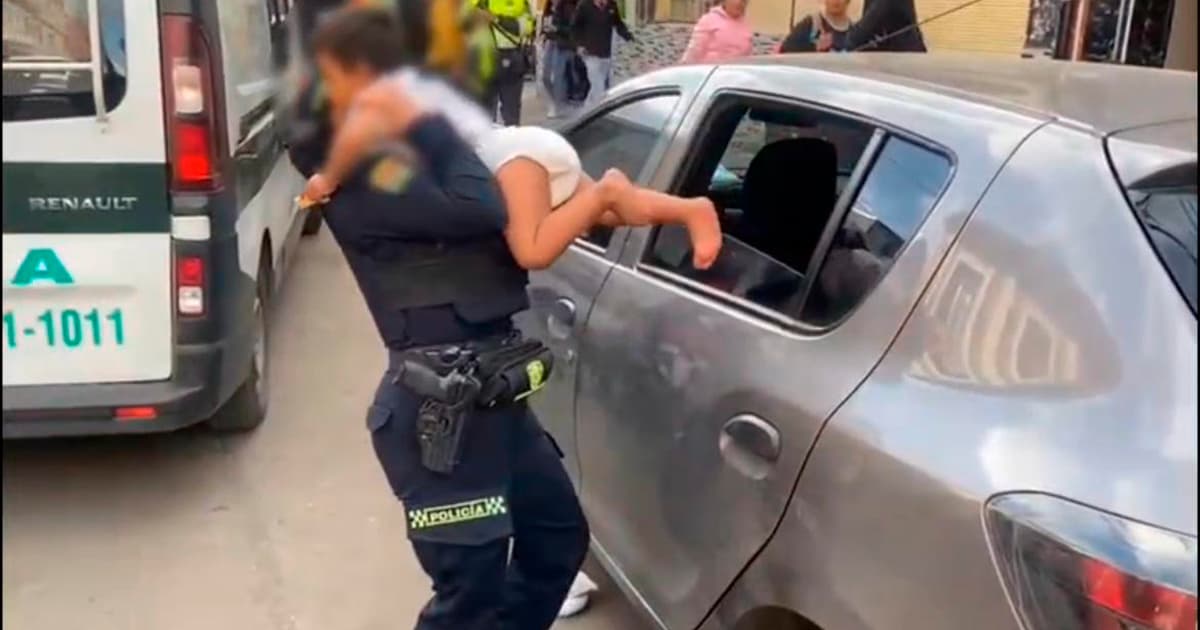 En la foto una mujer policía rescatando al menor de dos años encerrado en un carro 