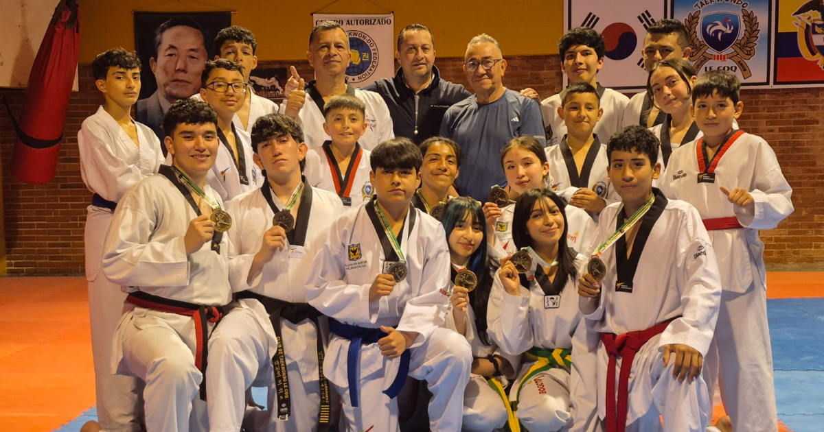 Niños y niñas tekwondistas posando con sus medallas