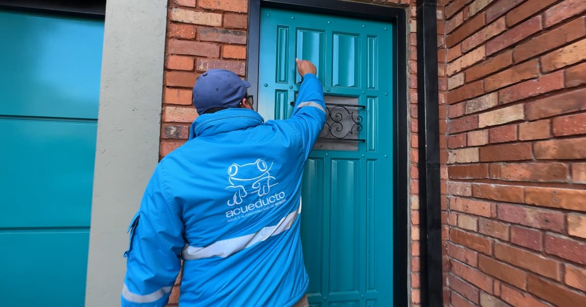 Funcionario del Acueducto golpeando en una casa 