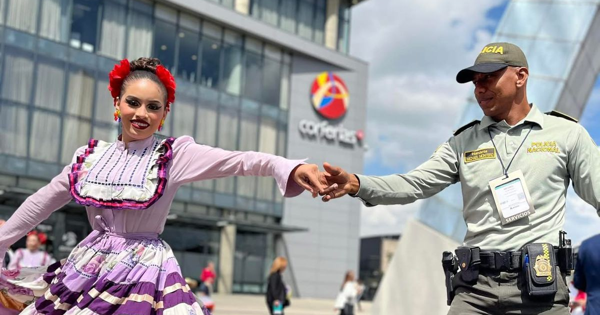Imagen de un Policía con una mujer vestida de un traje típico colombiano