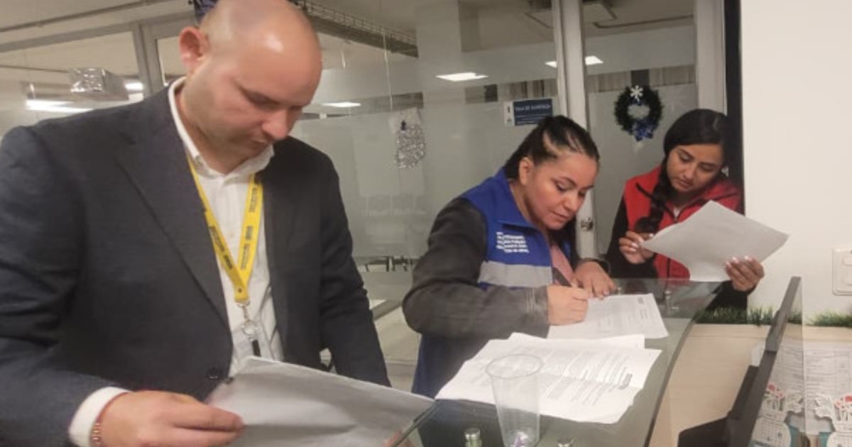Foto que muestra personas firmando papeles