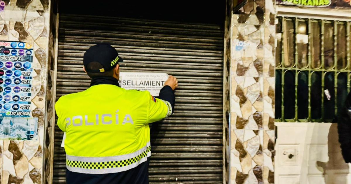 Imagen de un policía sellando un establecimiento 
