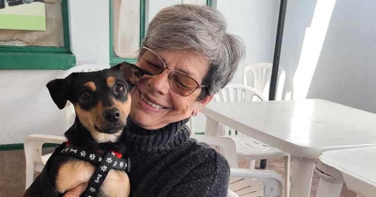 Imagen de una señora alzando a un perro