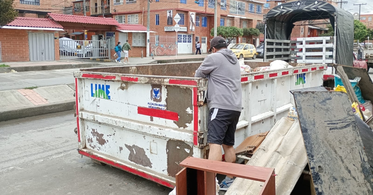 Foto que muestra una persona colocando residuos en un ecopunto 