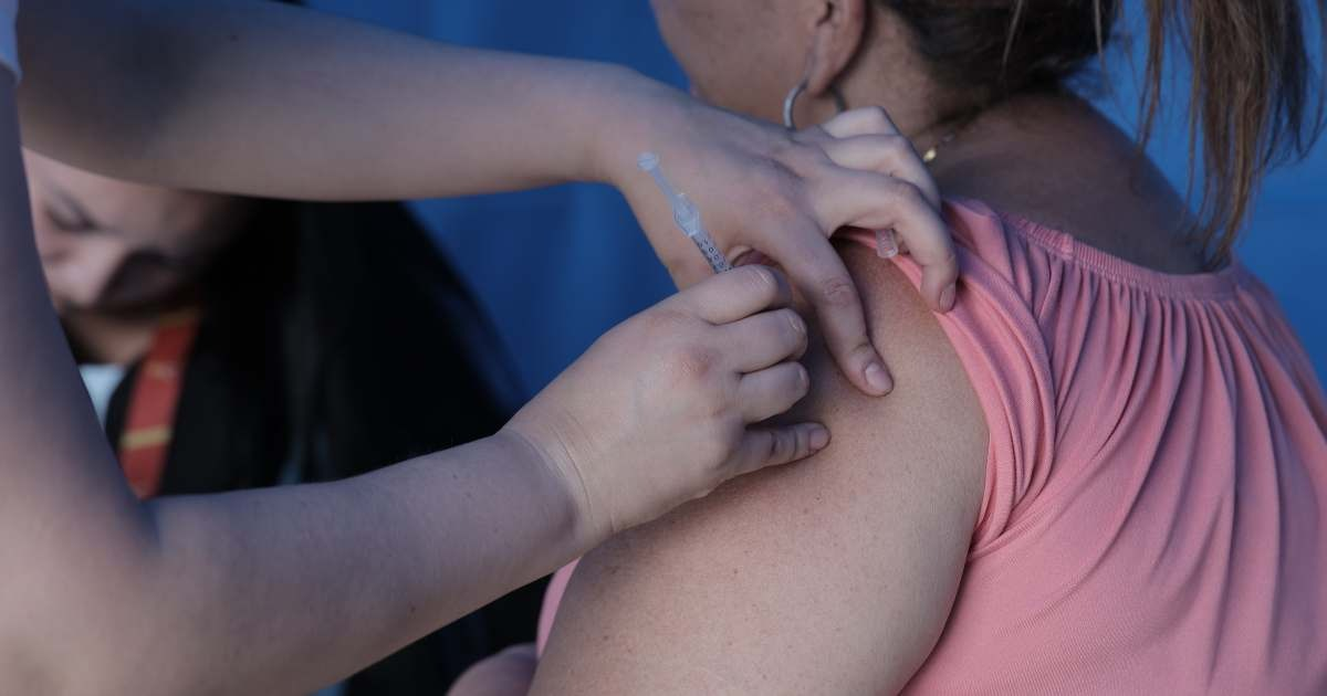 Imagen de unas manos que colocan una vacuna en un brazo