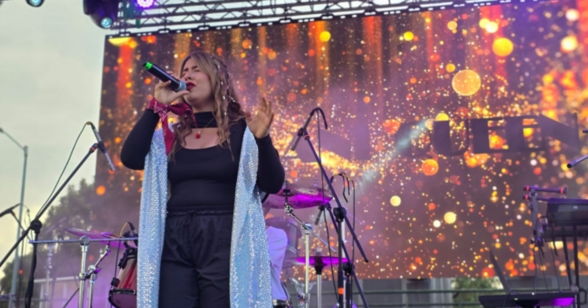 Imagen de una mujer cantando en una tarima