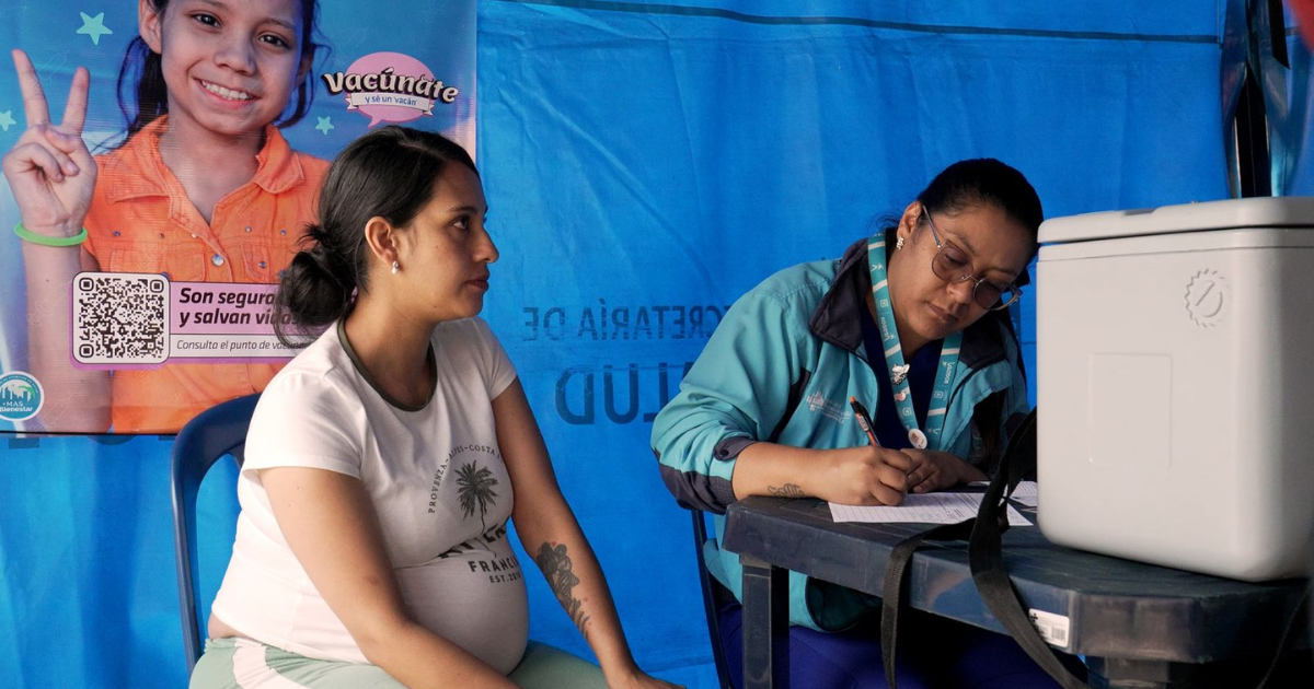 Foto de una enfermera colocando una vacuna en el hombro de una persona