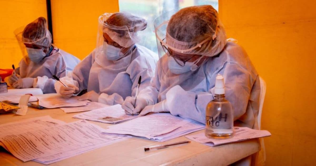 Foto que muestra enfermeras con un tapabocas puesto y escribiendo en un papel