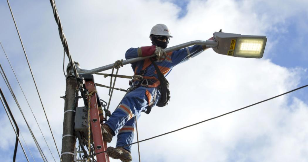 Imagen de un técnico de ENEL Codensa realizando mantenimiento en un poste de luz.