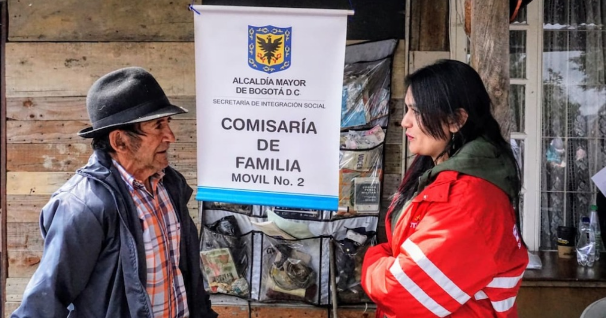 Imagen de una funcionaria de Integración Social junto a un adulto mayor