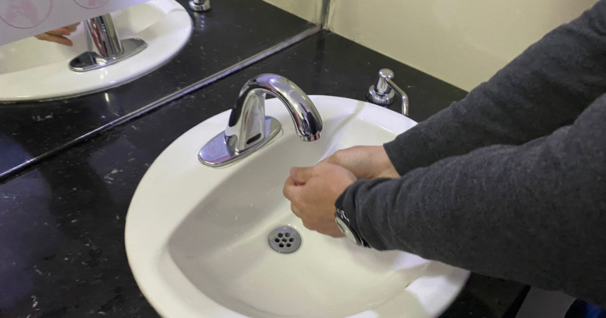 Foto que muestra una persona lavándose las manos