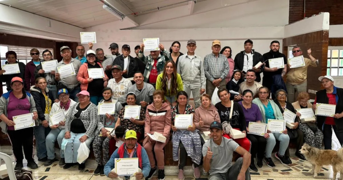 Foto que muestra un grupo de personas sonriendo y con un diploma en la mano