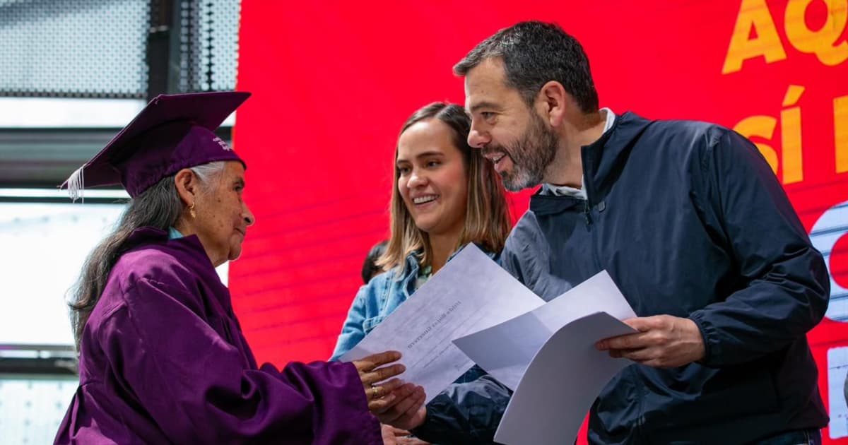 El alcalde Carlos Fernando Galán entregando un diploma a una mujer