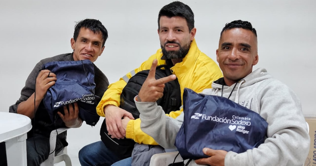 Imagen de tres personas con sus kits escolares