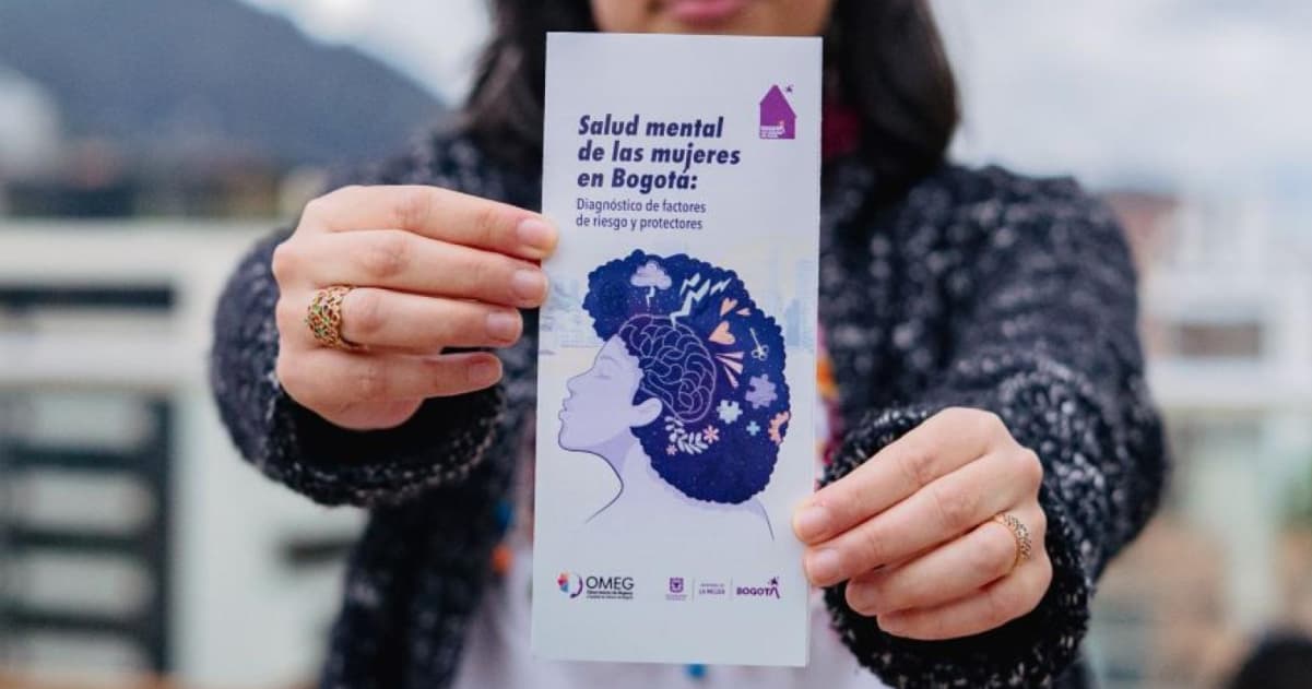 Mujer sosteniendo folleto de la Secretaría de la Mujer