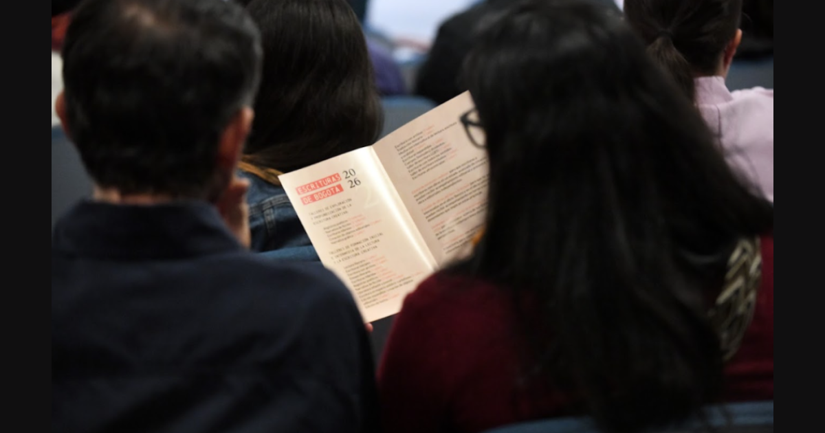 Imagen de un hombre y una mujer sentados leyendo un libro.