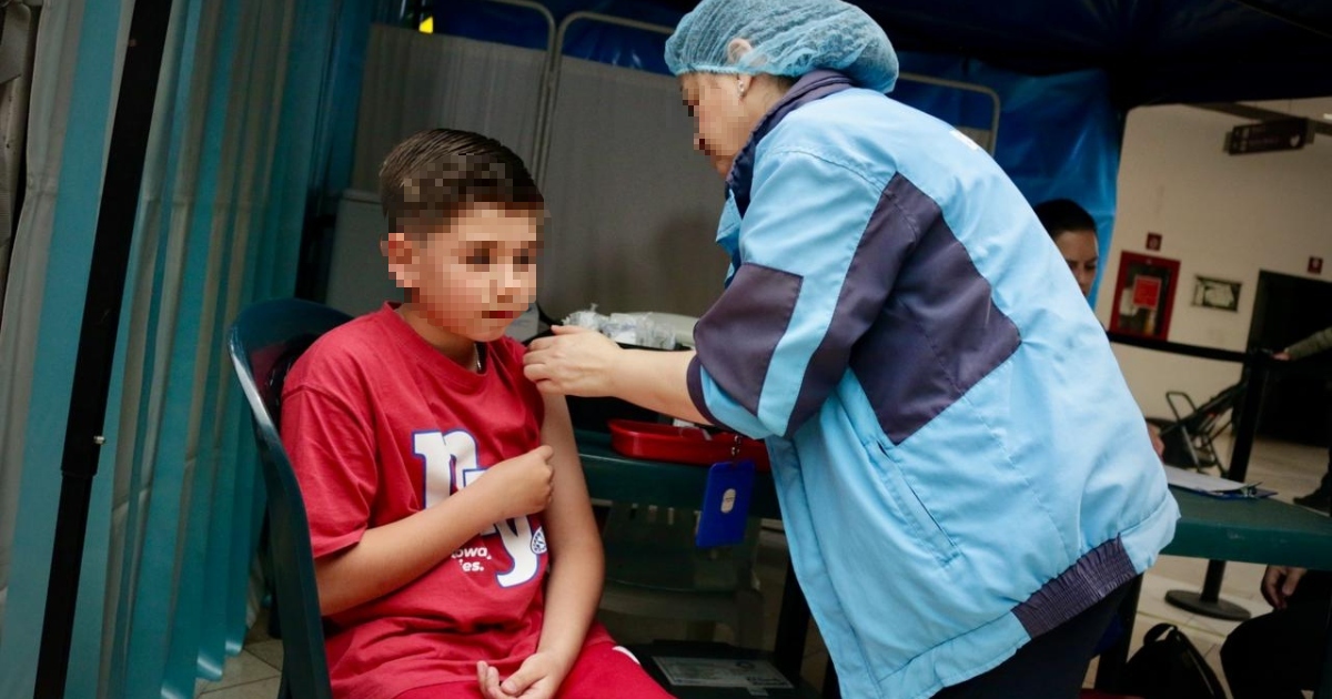 Foto que muestra una enfermera colocando una vacuna a un niño 