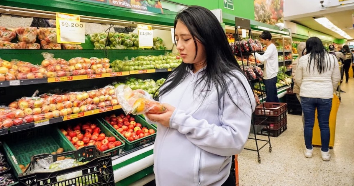 Imagen de una señora embarazada escogiendo un alimento en un supermercado