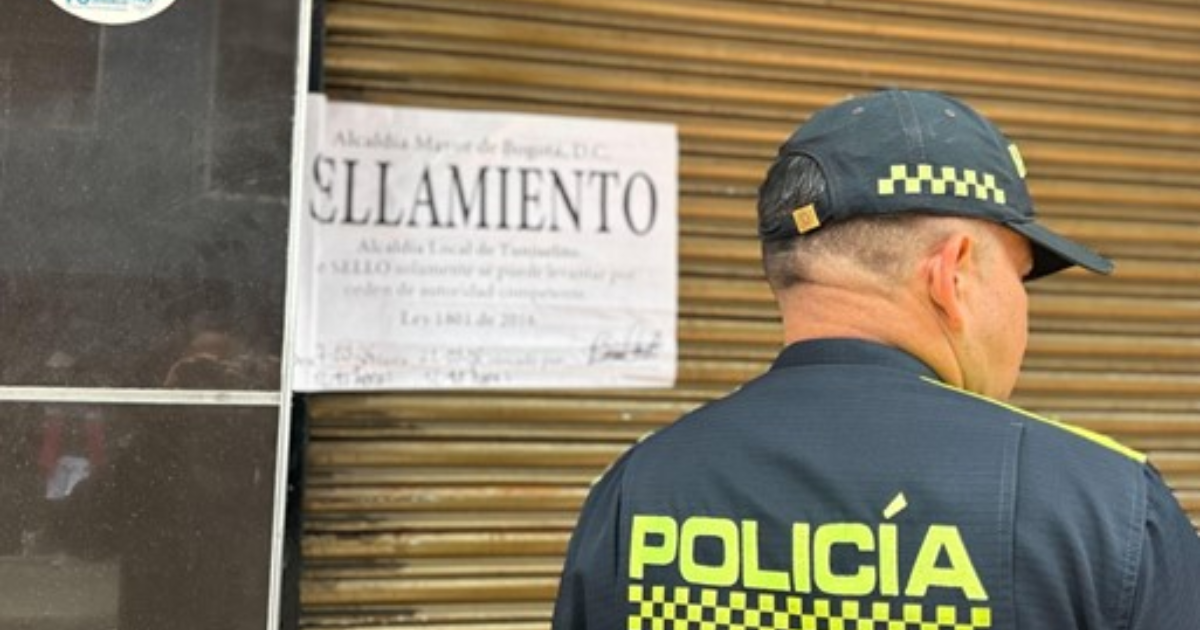 Imagen de un aviso de sellamiento y en primer plano la espalda de un policía